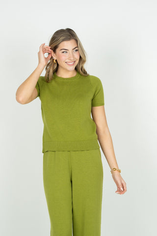 Woman wearing a green outfit against a white background