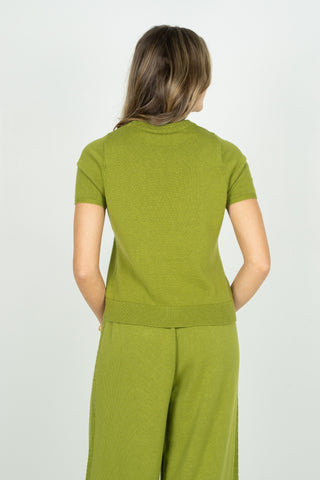 Woman wearing a green outfit with a plain background
