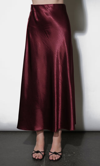 Maroon satin skirt worn by a person on a white background