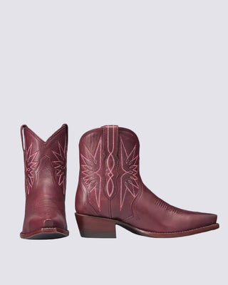 A pair of burgundy leather cowboy boots with pink western-style embroidery, shown from the front and side against a plain white background.