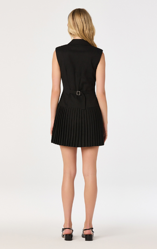 Elevate your wardrobe with this sleeveless blazer mini dress, where classic tailoring meets modern feminine style. Designed with a structured collared V-neckline and a sophisticated button-front closure, this chic blazer dress delivers a polished, fashion-forward look for work, special events, or nights out.

The tailored bodice creates a flattering silhouette, while playful pleated panels at the hem add graceful movement and a contemporary twist to the timeless blazer design. Finished in an above-the-knee 