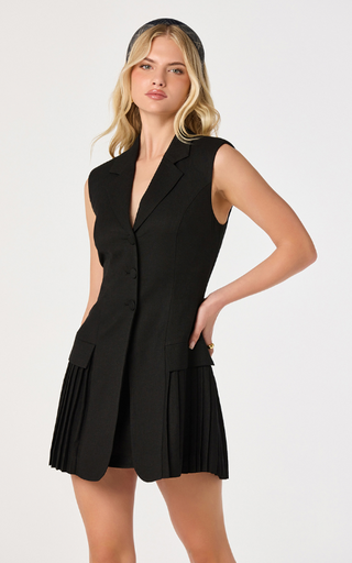 Elevate your wardrobe with this sleeveless blazer mini dress, where classic tailoring meets modern feminine style. Designed with a structured collared V-neckline and a sophisticated button-front closure, this chic blazer dress delivers a polished, fashion-forward look for work, special events, or nights out.

The tailored bodice creates a flattering silhouette, while playful pleated panels at the hem add graceful movement and a contemporary twist to the timeless blazer design. Finished in an above-the-knee 
