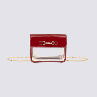 A red leather clutch bag with a clear transparent front panel and a gold horsebit clasp, featuring a gold chain strap, shown against a plain white background.